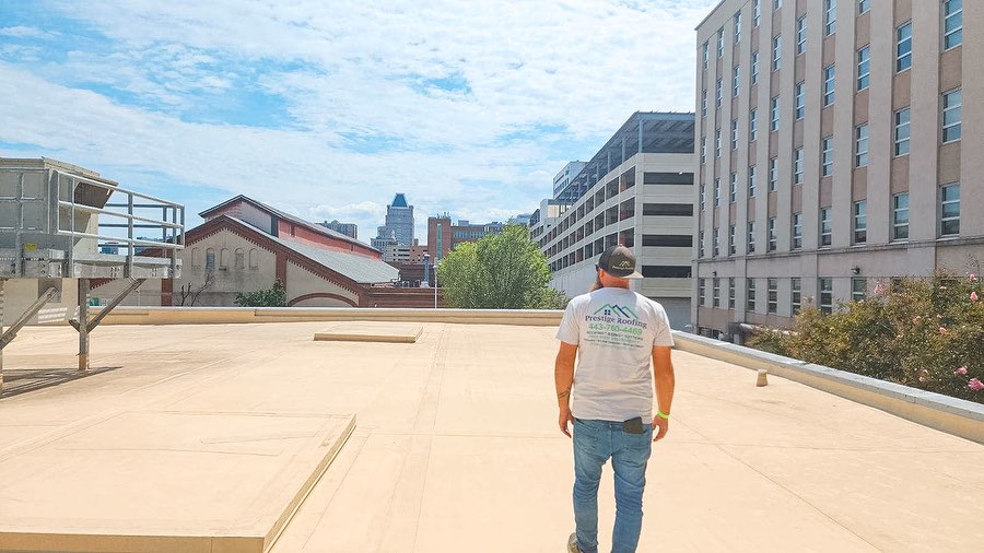 Picture of roofer on a flat roof in Maryland for the article "How Long Do Flat Roofs Last In Maryland"